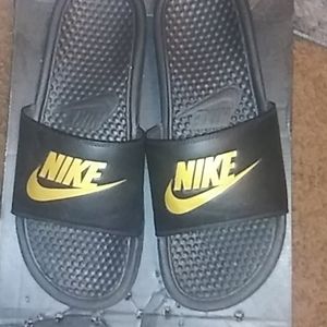 Black and gold Nike slides